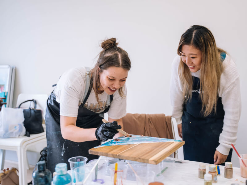 Two colleagues bond over making a resin board